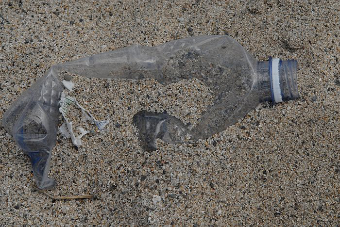 Bottiglia plastica nella sabbia