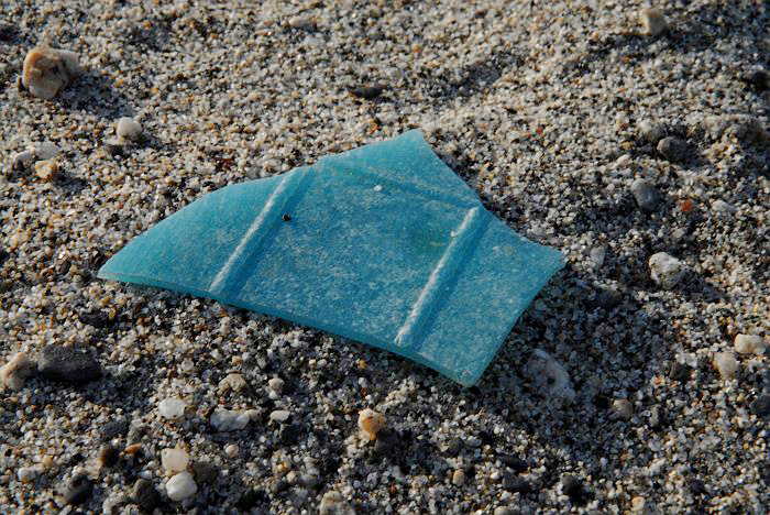 Pezzo plastica sulla sabbia